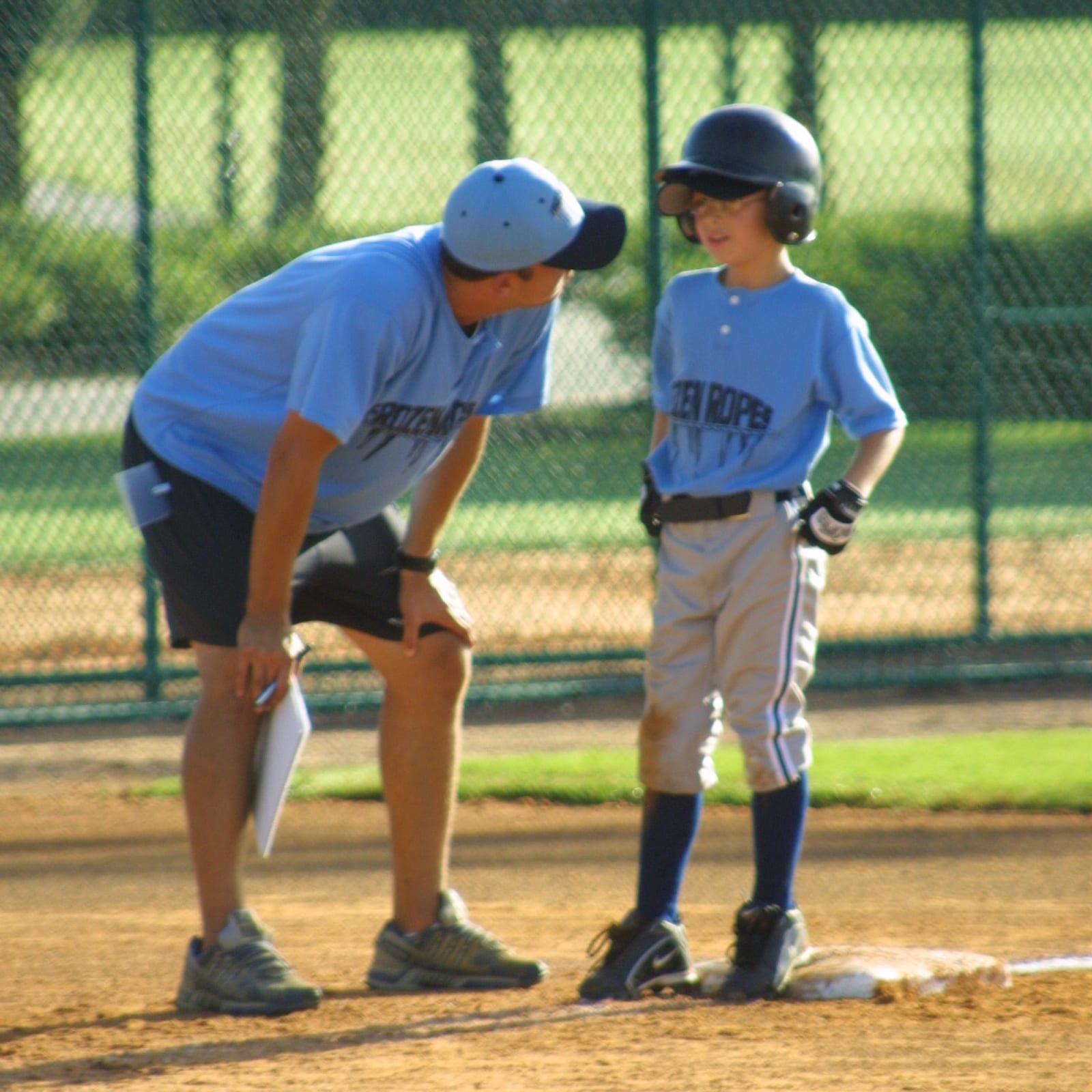 A Frozen Ropes coach working with a young base runner on game day